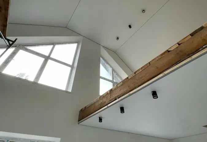 Сложный потолок с балками и встроенным светом в частном доме.